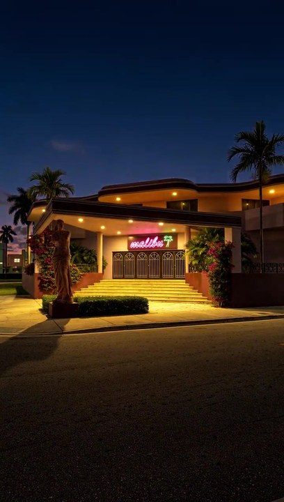 The same facade as the light falls to evening and its lights come on